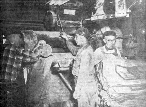 Mixing grain with molasses at E.T. and H.K. Ide Inc., is Murray Lyons, left. Henry Bumps pulls handle to regulate molasses flow and Samuel Eastman stacks empty grain bags.